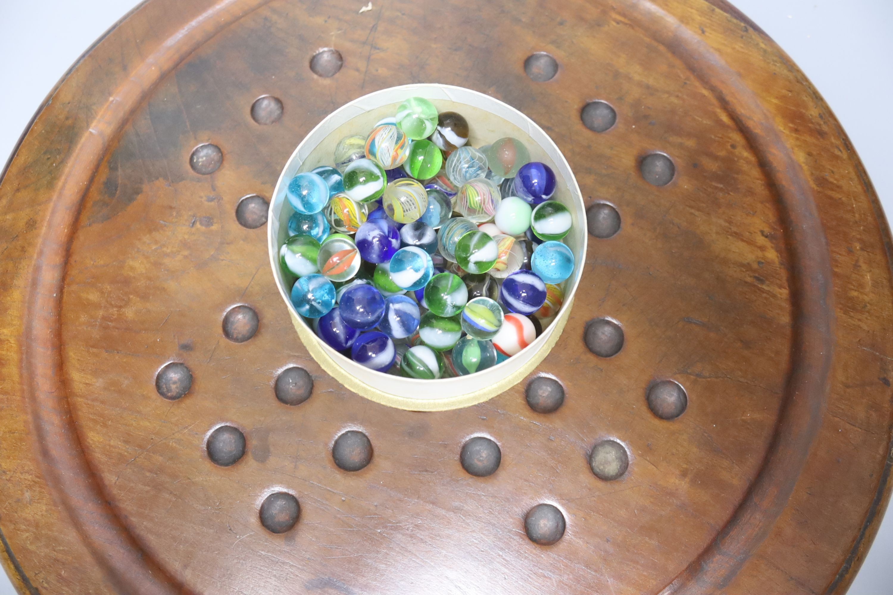 A collection of glass marbles and a mahogany solitaire board 45cm